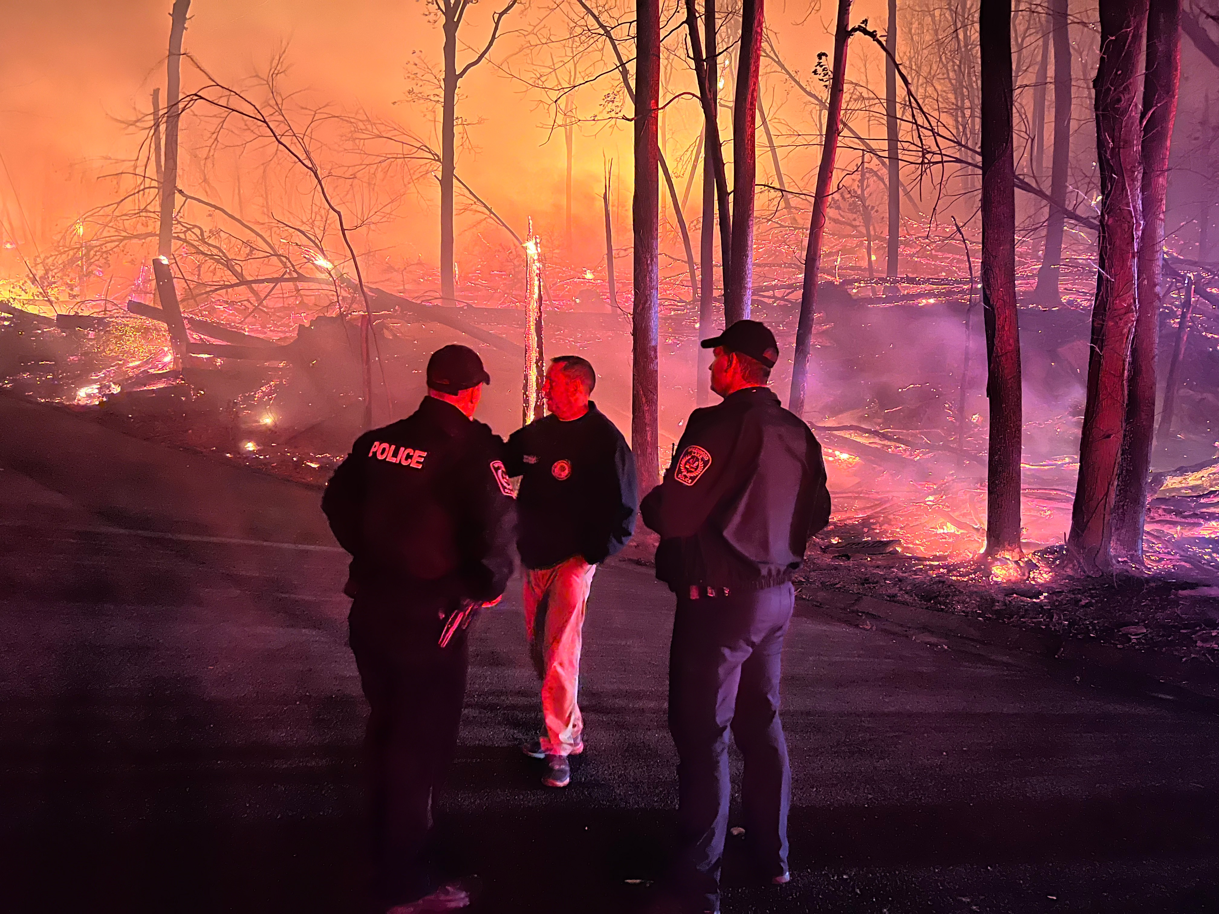 Steve Neuhaus assess fire damage with police officers